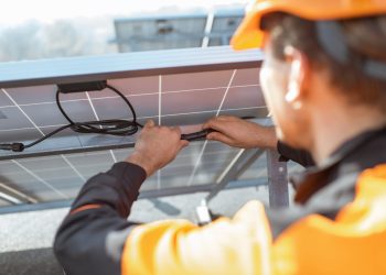 Electrician,Connecting,Wires,Of,Solar,Panels,On,A,Rooftop,Photovoltaic